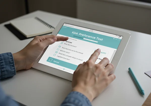 Person engaging with a digital kink preference test interface.